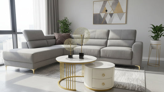 Modern living room with a brown sectional sofa, round white coffee table with gold legs, and decorative items.
