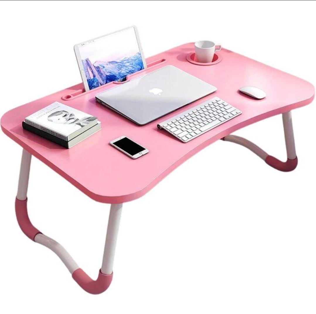 Pink laptop desk with a laptop, keyboard, and other items on a white background