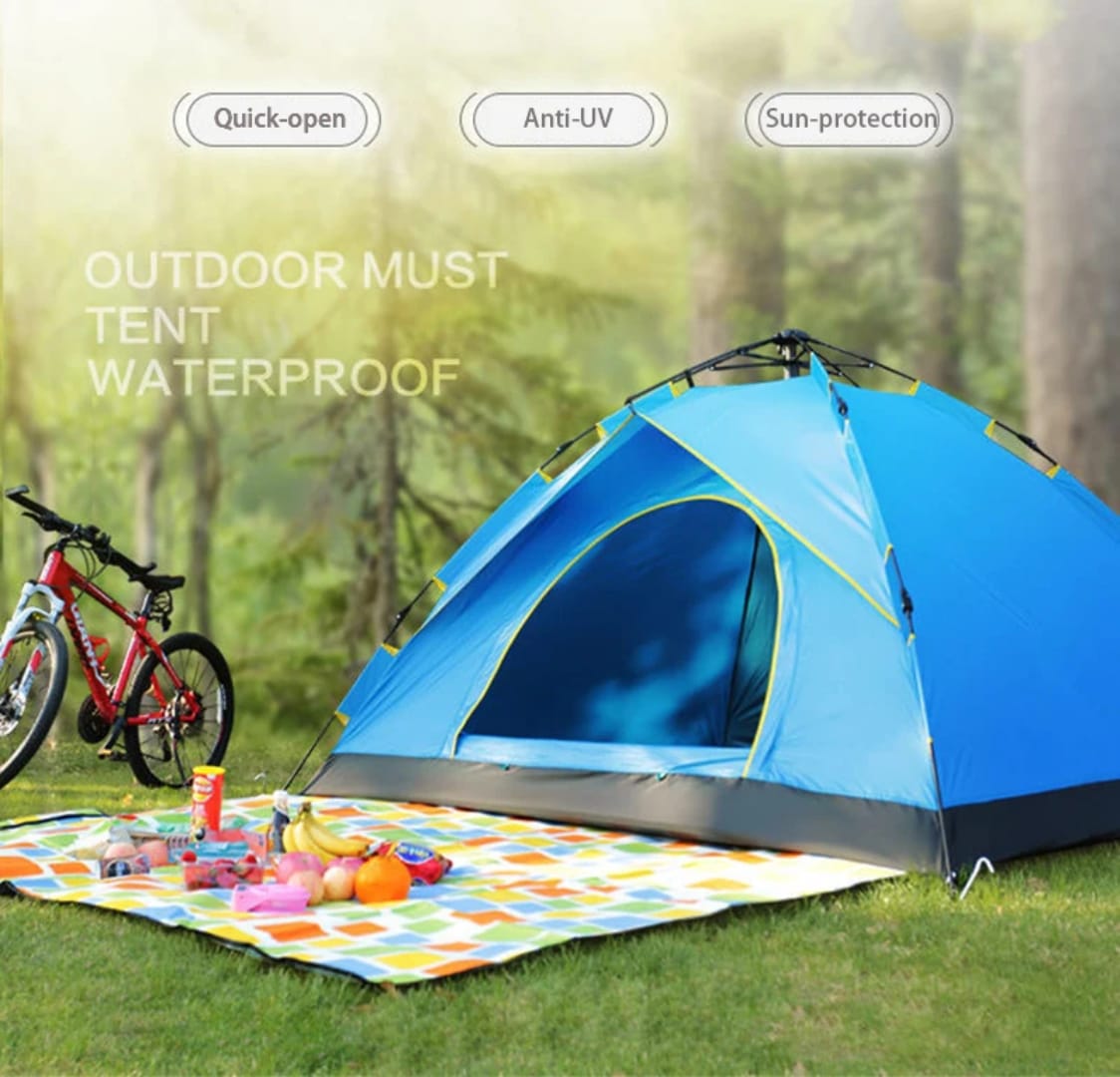 Blue tent with bike and picnic setup in a forest