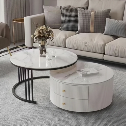 Round marble coffee table with a white base in a living room setting.