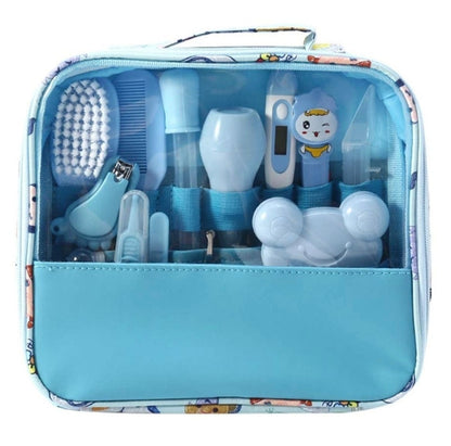 A baby diaper changing kit in a zippered storage bag. The kit contains light blue and white plastic tools including a brush, nail clipper, thermometer, and applicators, all neatly organized inside a light blue bag with a cartoon patterned border.