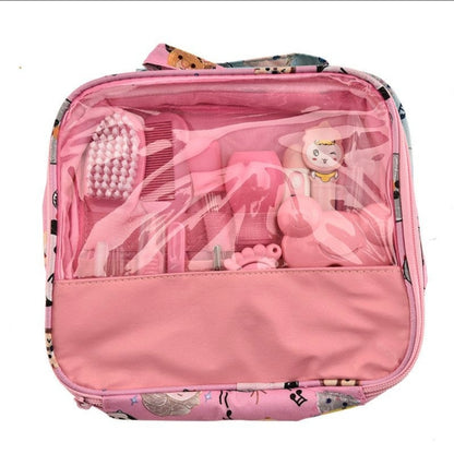 Pink travel case with hairbrush, hair accessories, and a toy inside on a white background