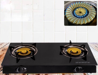 Black gas stove with two burners on a wooden surface and white tiled wall background.